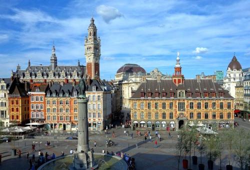 uma cidade com uma torre de relógio e um grande edifício em Gare LILLE FLANDRES Incroyable emplacement em Lille