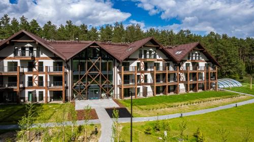 an exterior view of a large building with trees at Apartamenty Sun & Snow Zapach Lasu - Naturalne SPA in Karwica