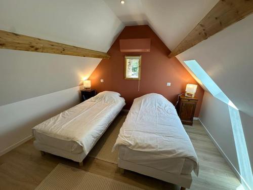 deux lits dans une chambre avec un grenier dans l'établissement La Petite Bergerie 3 etoiles, à Dampsmesnil