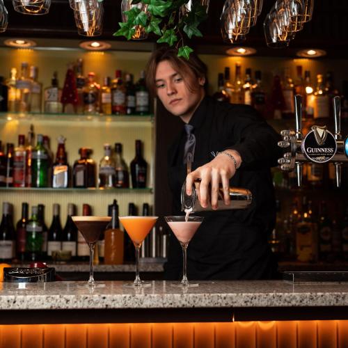 a man is making a drink at a bar at Brig o' Doon House Hotel in Ayr