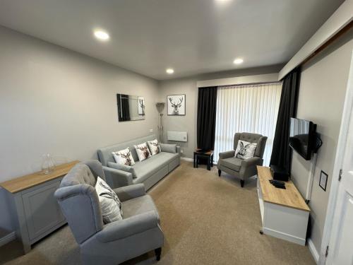 a living room with a couch and two chairs at Quaysiders Lakes Resort - Quaysiders Club in Ambleside