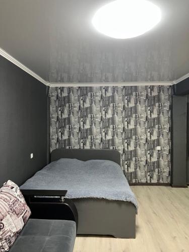 a bedroom with a bed and a wall with a wallpaper at Квартира апартамент люкс in Balqash