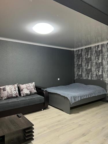 a bedroom with a bed and a black wall at Квартира апартамент люкс in Balqash