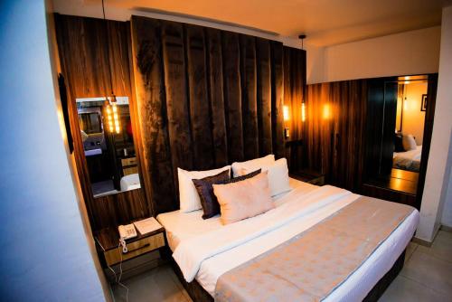 um quarto com uma cama grande e uma parede de madeira em Vic & J Lounge and Hotel Asaba em Asaba