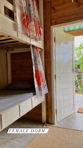 a bunk bed in a room with a open door at Jambiani Backpackers Hostel in Jambiani