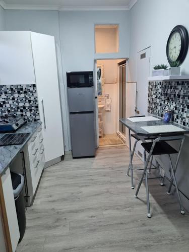a kitchen with a table and a clock on the wall at Twelveon1st in Cape Town