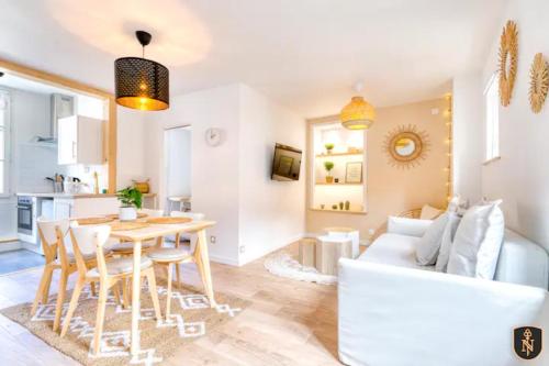 ein Wohnzimmer mit einem Tisch und einem weißen Sofa in der Unterkunft La Casa Relaxio — Un nid douillet en hyper centre in Caen