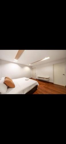 1 dormitorio con 1 cama blanca grande y 1 habitación con armarios en 城市公寓, en Klong Toi