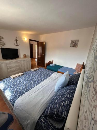 a bedroom with a large bed and a flat screen tv at Casa Beta in Castelsardo