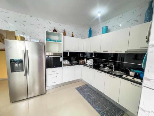 una cucina con armadi bianchi e frigorifero in acciaio inossidabile di Zeyden Place Apt 2 a Praia