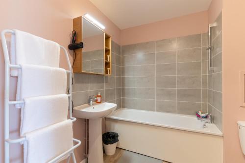 een badkamer met een wastafel, een bad en een toilet bij Moulin à Vent Nord - Appt à 20 minutes de Paris in Bondy