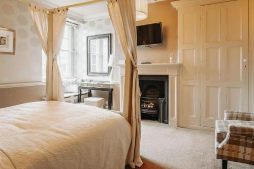 sypialnia z łóżkiem z baldachimem i kominkiem w obiekcie Old Orleton Inn w mieście Wellington