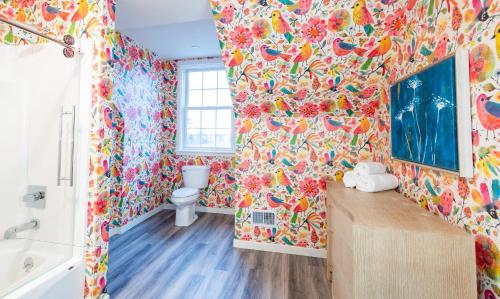 The Inn at Stonecliffe في ماكيناك أيلاند: حمام مع ورق جدران ملونة ومرحاض وحوض استحمام