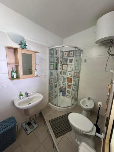 a bathroom with a toilet and a sink and a shower at Casa Beta in Castelsardo