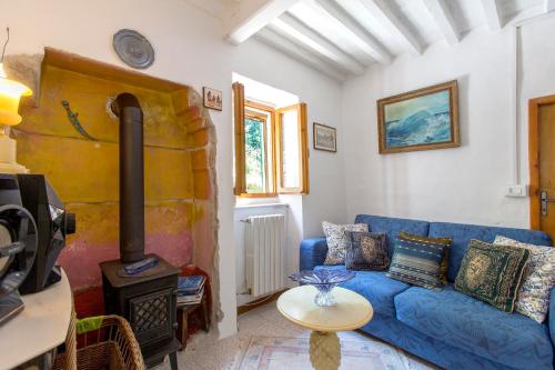 a living room with a blue couch and a wood stove at Casina Orione in Montecatini Val di Cecina