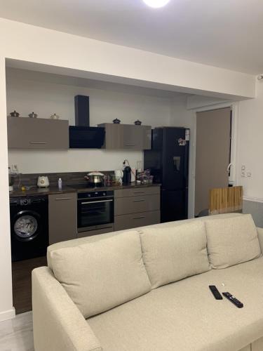 - un salon avec un canapé en face d'une cuisine dans l'établissement Appartement Cosy proche aéroport CDG ROISSY, à Garges-lès-Gonesse