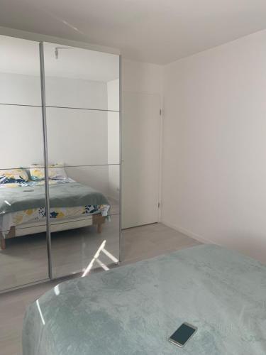une chambre avec un lit et un miroir dans l'établissement Appartement Cosy proche aéroport CDG ROISSY, à Garges-lès-Gonesse
