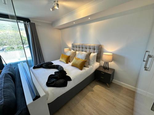 1 dormitorio con 1 cama y ventana grande en The Westwood Deluxe Studio, en Ciudad del Cabo
