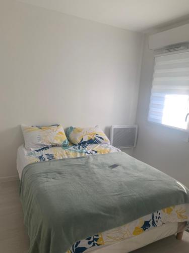 un lit dans une chambre blanche avec une fenêtre dans l'établissement Appartement Cosy proche aéroport CDG ROISSY, à Garges-lès-Gonesse
