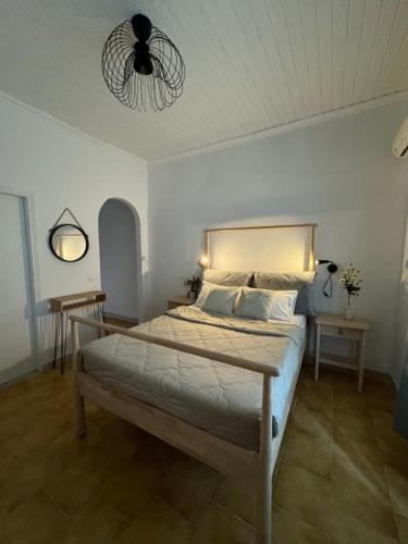 a bedroom with a bed and a ceiling fan at Elena’s apartments in Perivólion