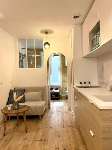 une cuisine et un salon avec un canapé et une table dans l'établissement Studio Bordelais avec terrasse, à Bordeaux