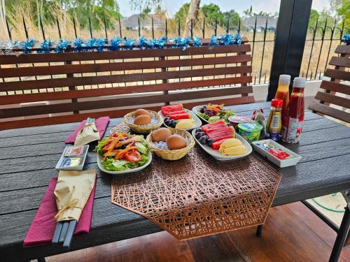 una mesa de picnic con platos de comida. en Paradise Pool Villa at My Second home, en Ban Chang