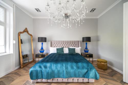 a bedroom with a large bed and a chandelier at Keszthely Balaton Luxury Villa in Keszthely