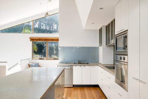 a kitchen with white cabinets and a large window at 3-Bed Seaside Serenity Escape at Long Beach in Long Beach