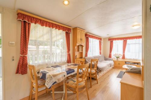 une cuisine et une salle à manger avec une table et des chaises dans l'établissement Mobilhome Mh287 La Tremblade, à La Tremblade