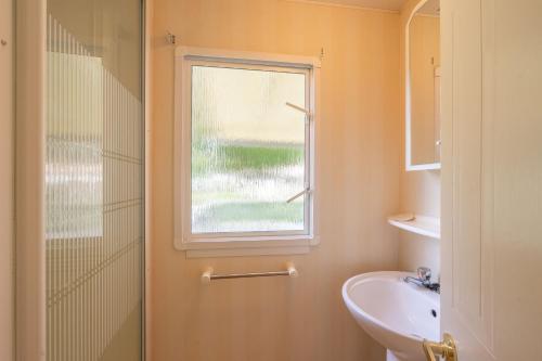 une salle de bain avec une douche et un lavabo et une fenêtre dans l'établissement Mobilhome Mh287 La Tremblade, à La Tremblade