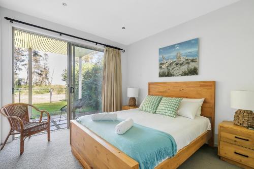 a bedroom with a bed and a sliding glass door at 3-Bed Seaside Serenity Escape at Long Beach in Long Beach