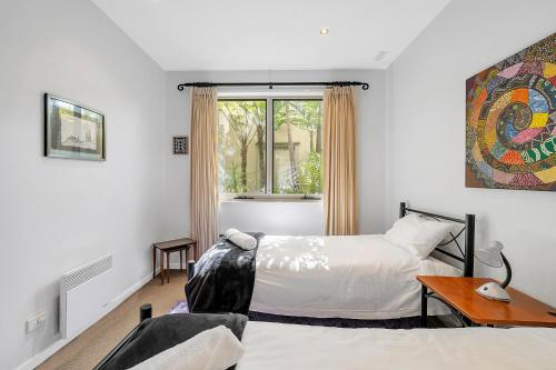 two beds in a room with a window at 3-Bed Seaside Serenity Escape at Long Beach in Long Beach
