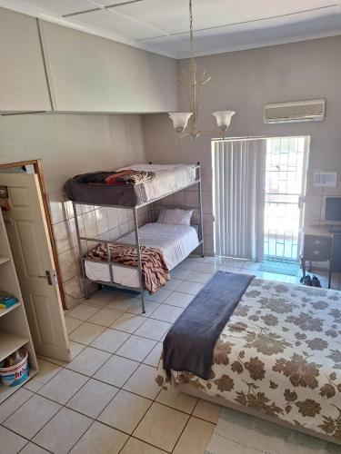 a bedroom with a bunk bed and a tiled floor at Breaking Dawn in Noupoort