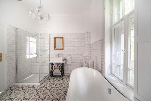 uma casa de banho branca com uma banheira e um lavatório em Keszthely Balaton Luxury Villa em Keszthely