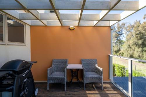 a patio with two chairs and a table on a balcony at 3-Bed Seaside Serenity Escape at Long Beach in Long Beach