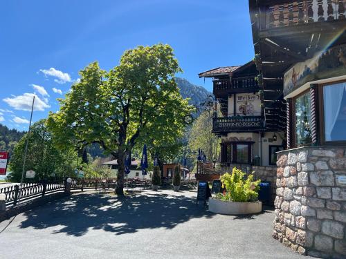 a building with a tree in the middle of a street at Ferienapartment Residenz "Weisses Rössl am See" in Thiersee