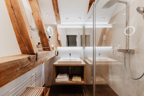 uma casa de banho com 2 lavatórios e um chuveiro em Landhaus Koller em Gosau
