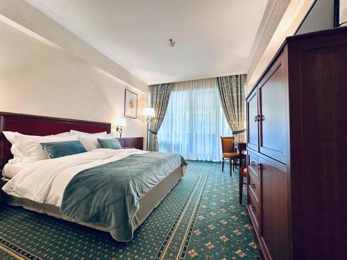 a hotel room with a bed and a window at Lux Garden Hotel in Azuga