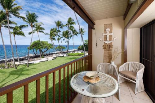 a balcony with a table and chairs and the ocean at Kona Isle E23 in Kailua-Kona