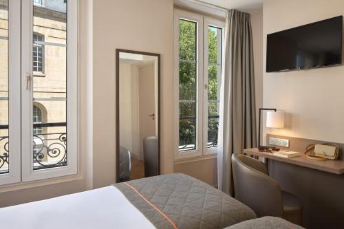 パリにあるティムホテル ガル ドゥ レスト（旧 ア ラ ヴィラ サン マルタン）のベッドと窓が備わるホテルルーム