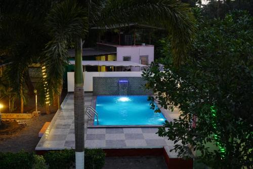 a swimming pool in front of a house at night at Kamal Homes in Kīhīm