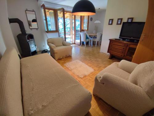 a living room with a couch and chairs and a tv at Garden House in Sarajevo