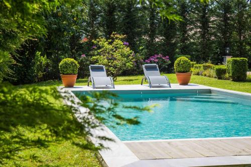 - deux chaises et une piscine dans la cour dans l'établissement Maison Cuevas, à Biarritz
