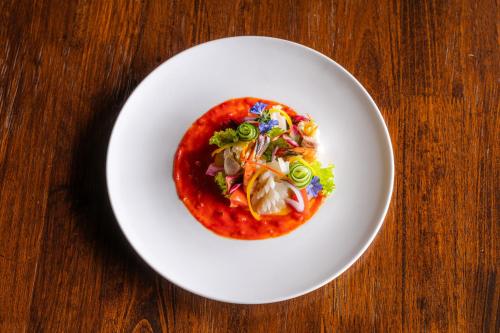 a white plate of food on a wooden table at Simpson's Forest - Luxury Boutique Resort & Spa - Kandy in Kandy