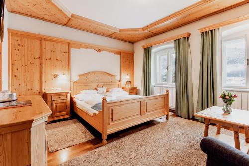 a bedroom with a large bed and two windows at Landhaus Koller in Gosau