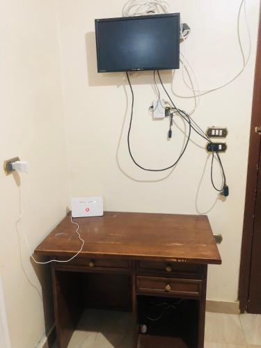 einen Holzschreibtisch mit einem TV an der Wand in der Unterkunft شقة بدمياط الجديدة مناطق هادئة in Dumyat al Jadidah