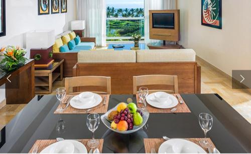 a living room with a table with a bowl of fruit at Mayan Palace Vidanta in Nuevo Vallarta 