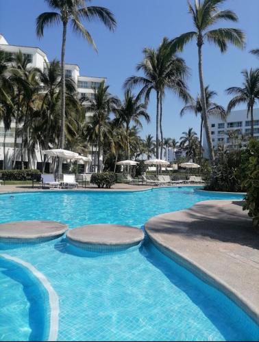 a swimming pool with palm trees in a resort at Mayan Palace Vidanta in Nuevo Vallarta 