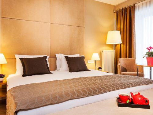 イスタンブールにあるNidya Hotel Esenyurtの大きなベッドと椅子が備わるホテルルームです。