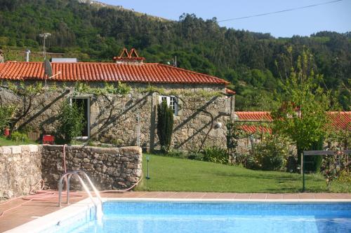 une villa avec une piscine en face d'une maison dans l'établissement Casa do Ribeiro - Casal Pedro, à Ponte de Lima